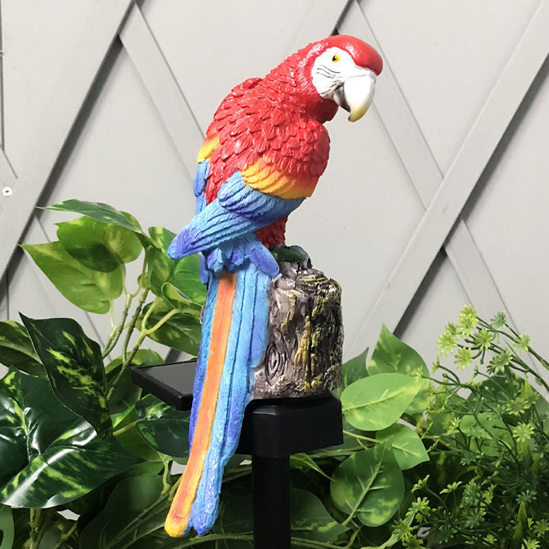 Colorful parrot statue on a stand with plants in the background
