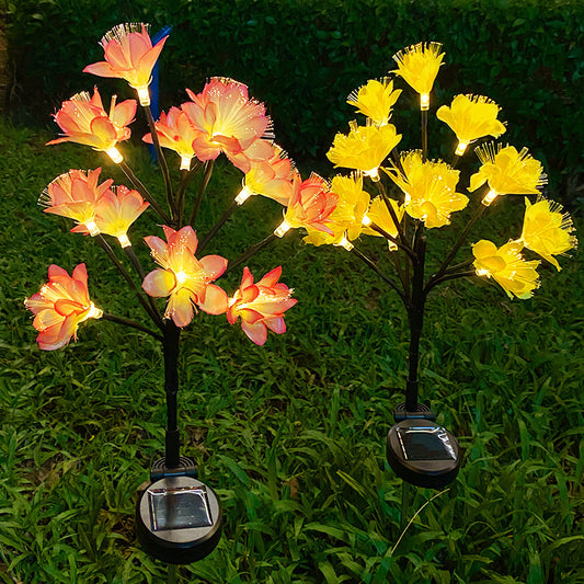Solar-powered flower lights in pink and yellow on grass