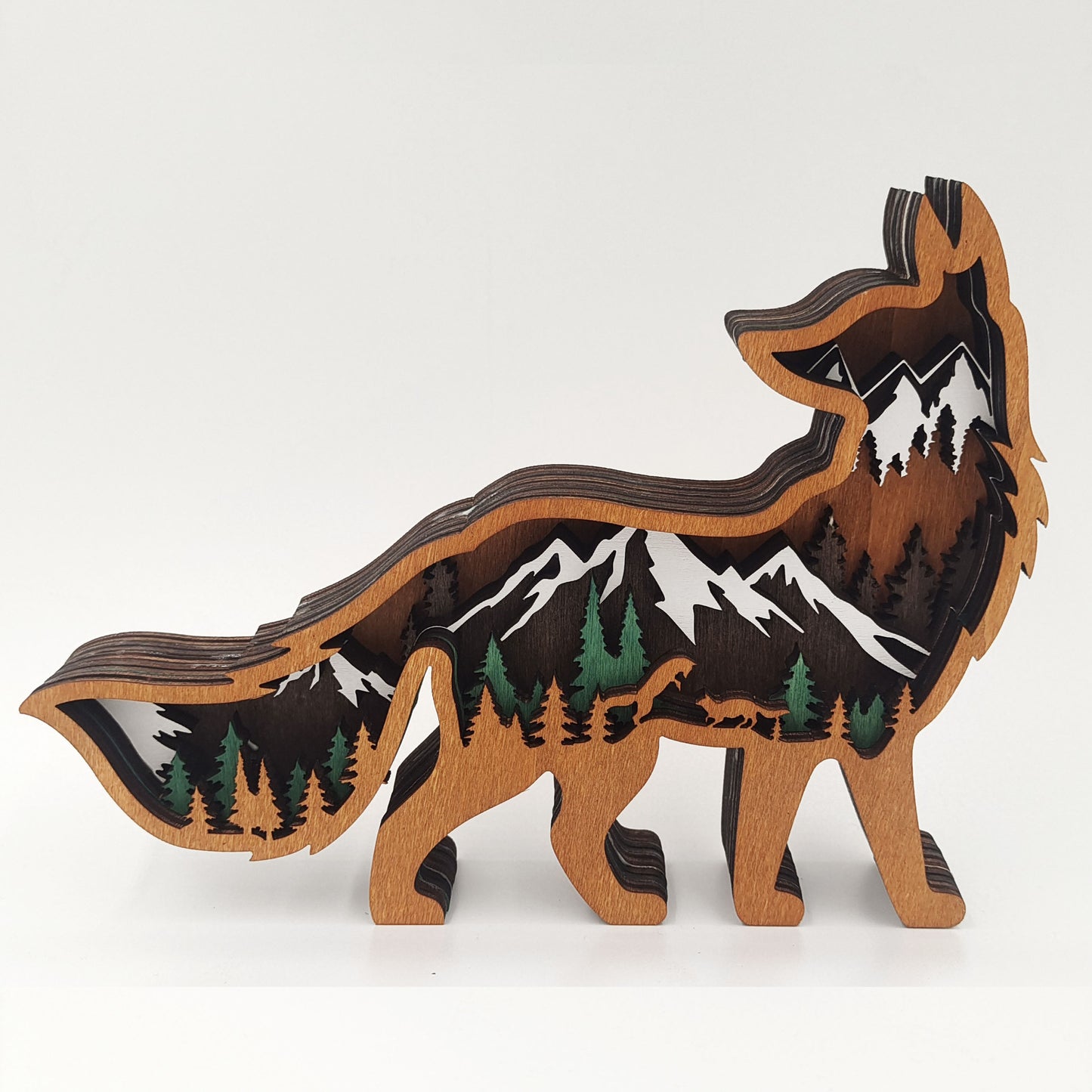 Wooden wolf sculpture with mountain and forest design on a white background