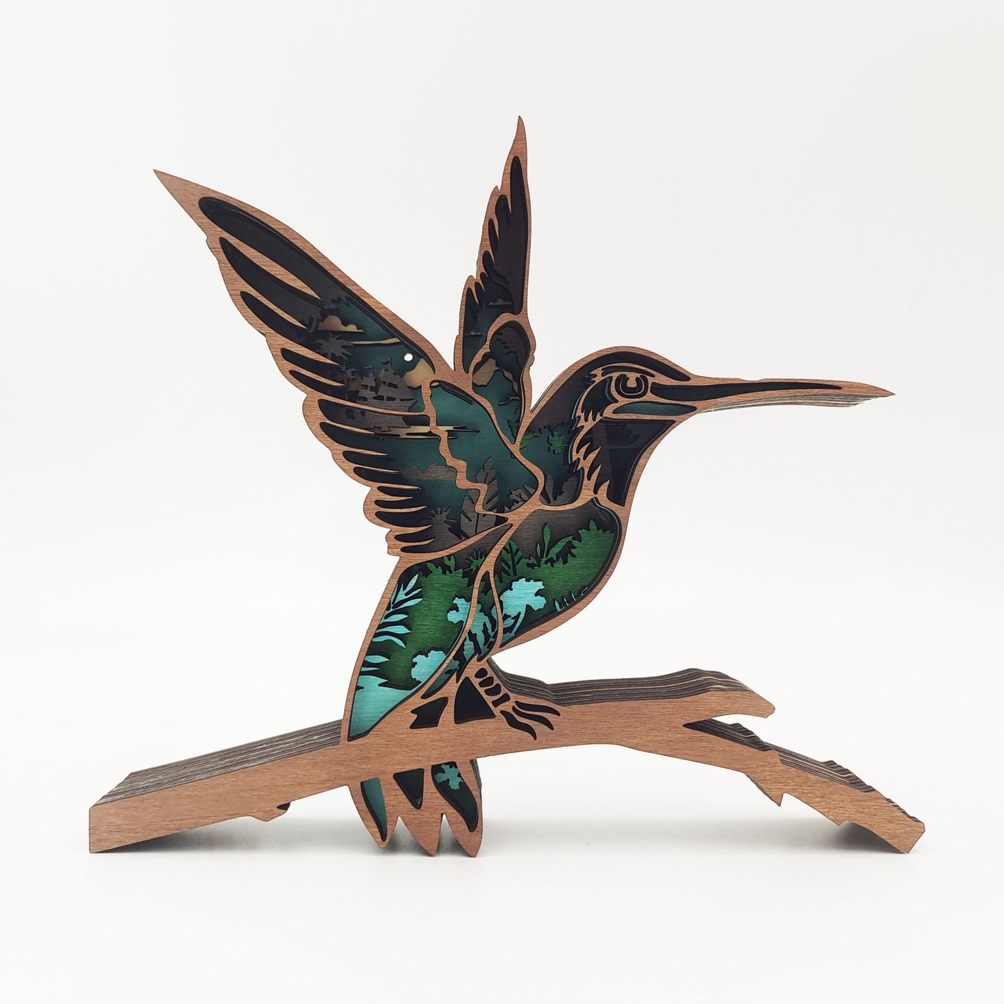 Decorative hummingbird sculpture on a branch with green and brown colors on a white background