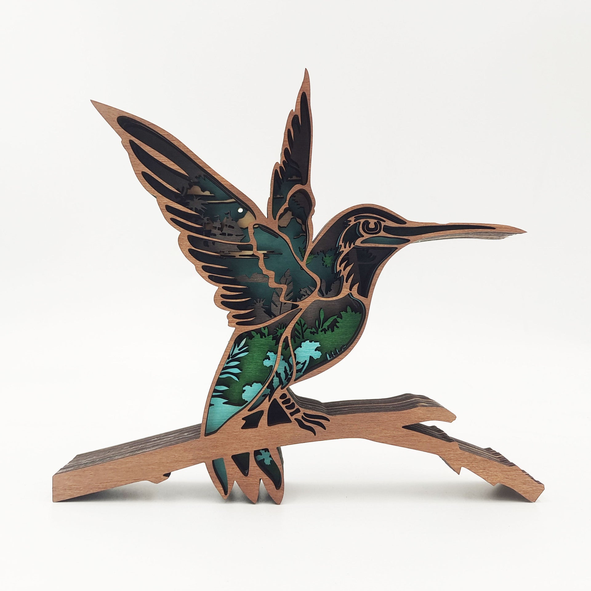 Decorative hummingbird sculpture on a branch with green and brown colors on a white background