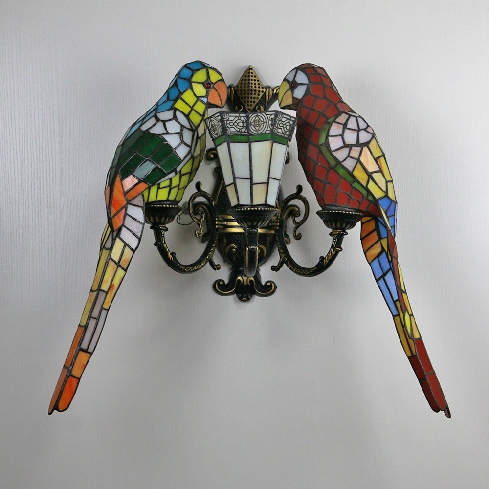 Decorative wall sconce with stained glass parrot design on a plain background
