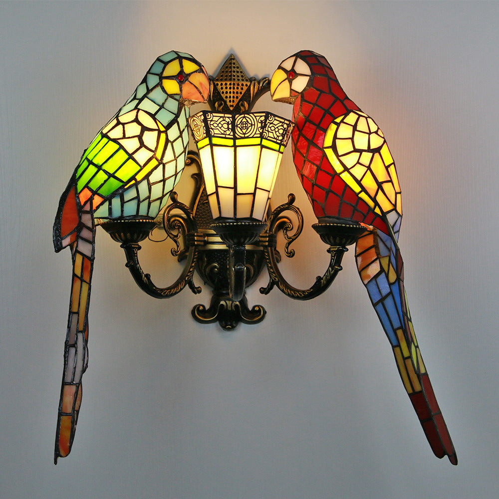 Stained glass wall sconce shaped like a parrot on a plain background