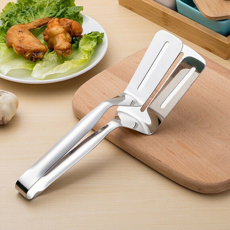 Metallic vegetable peeler on a wooden cutting board with a plate of food in the background