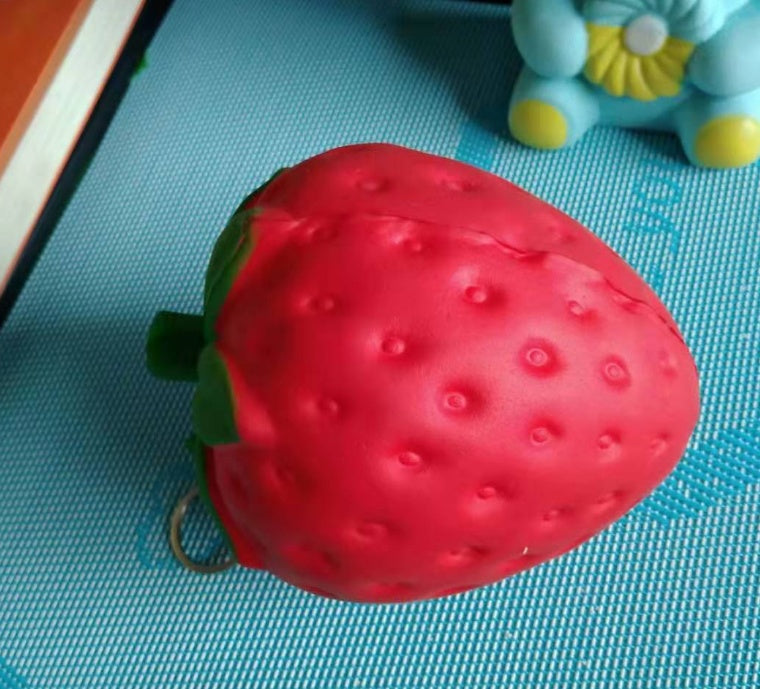 Red strawberry-shaped object on a blue textured surface