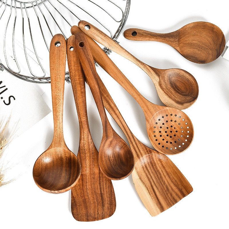 Set of wooden cooking utensils including spoons and a spatula on a white background.