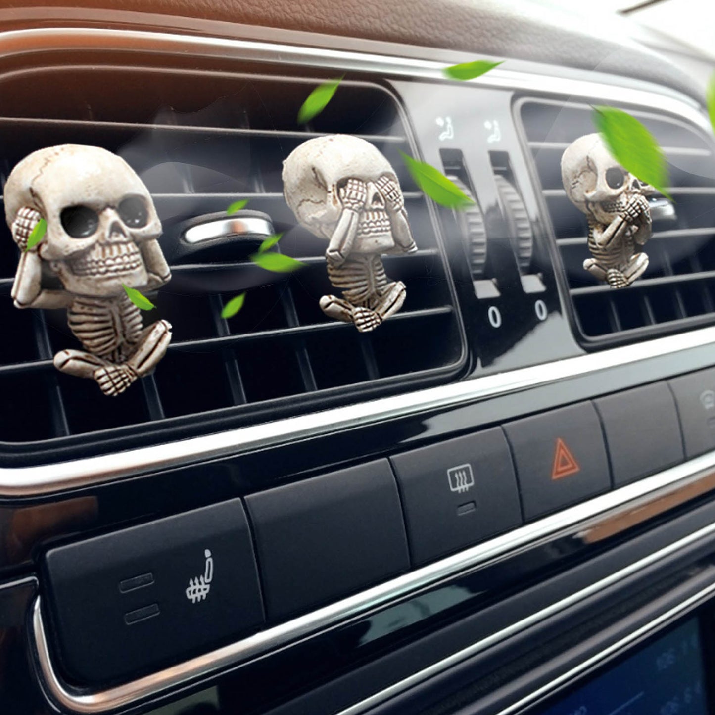 Three skeleton-themed car air fresheners on a car's air vent.