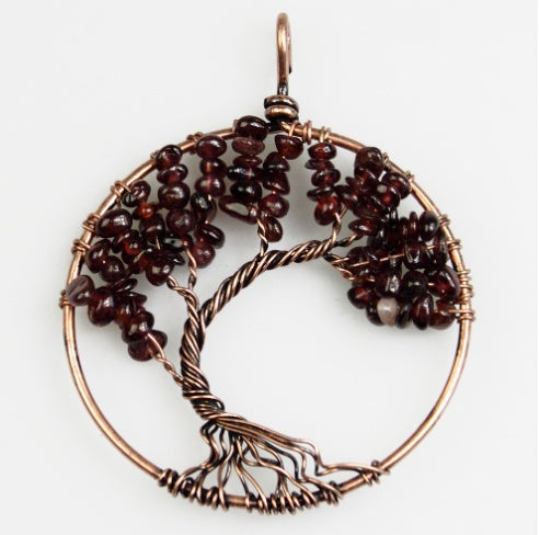 Tree-shaped pendant with brown beads and copper wire on a white background