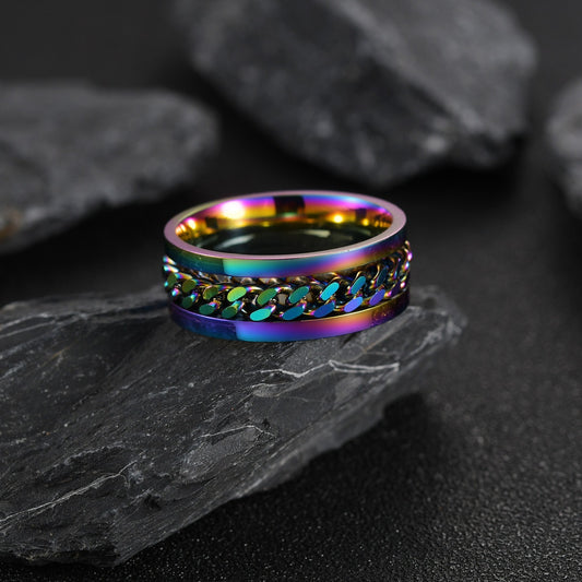 Multicolored ring on a dark stone surface with rocks in the background