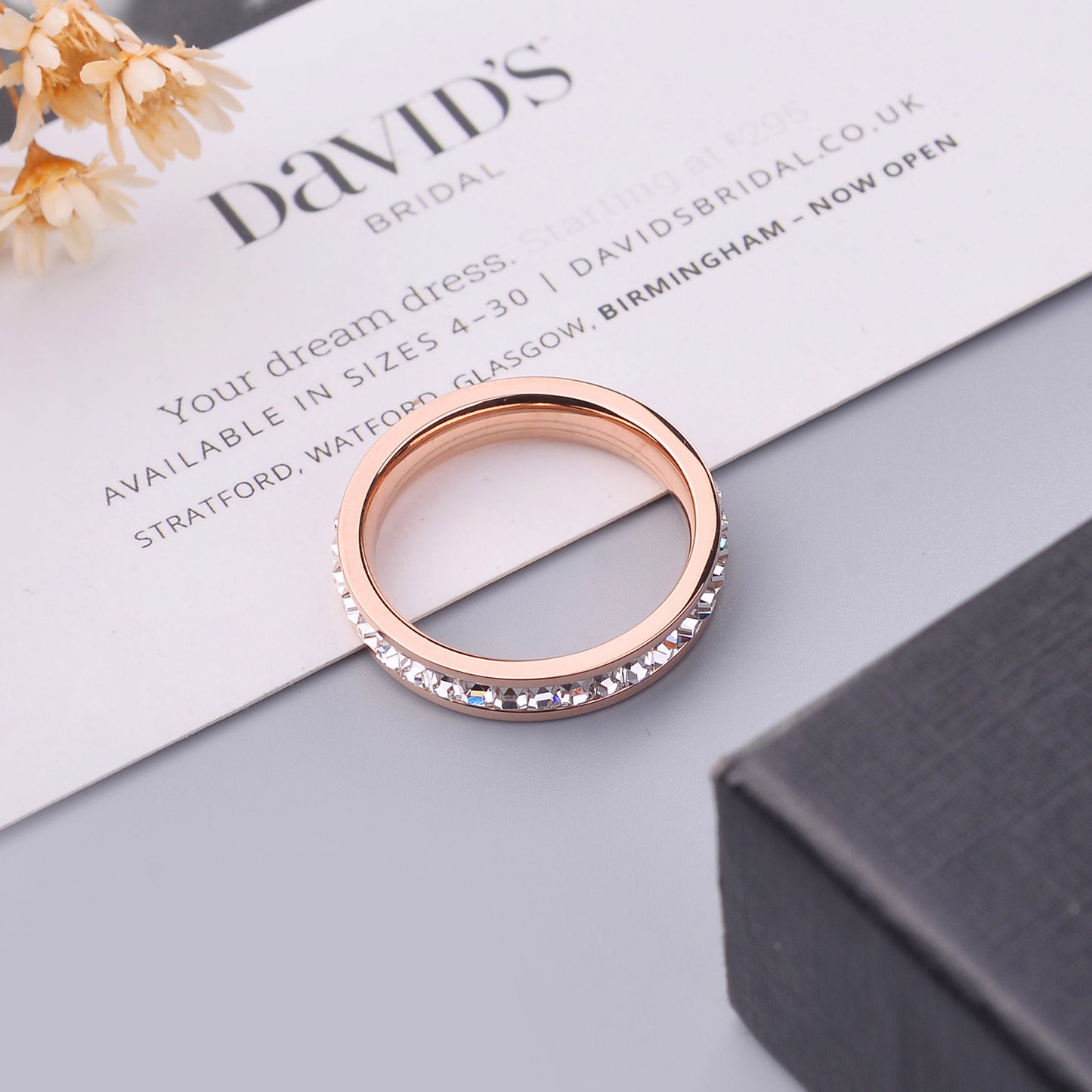Rose gold ring with embedded stones on a 'David's Bridal' leaflet.