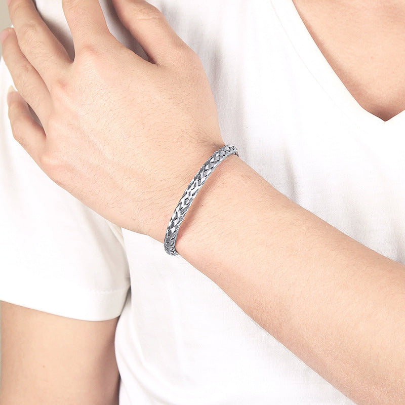 Silver bracelet on a person's wrist against a white background