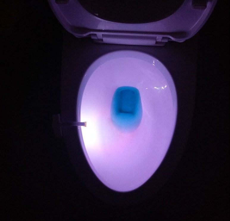 Toilet bowl with glowing purple light on a black background