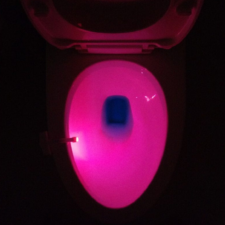 Glowing pink toilet seat in the dark