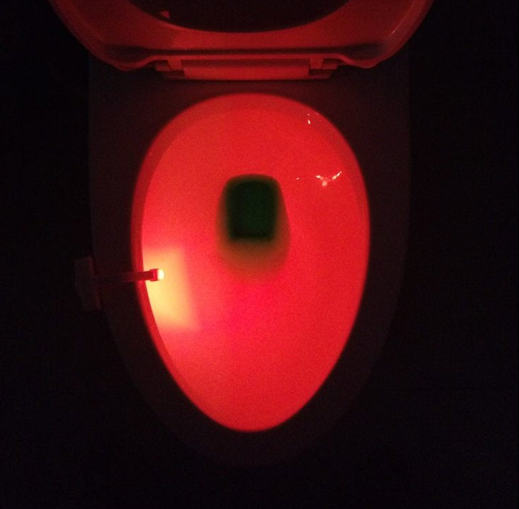 Red glowing toilet seat in a dark setting