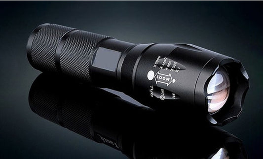 Black flashlight with visible branding on a dark background