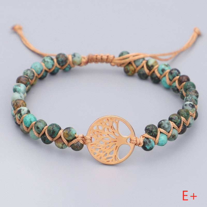 Beaded bracelet with a gold tree-shaped clasp on a light gray background