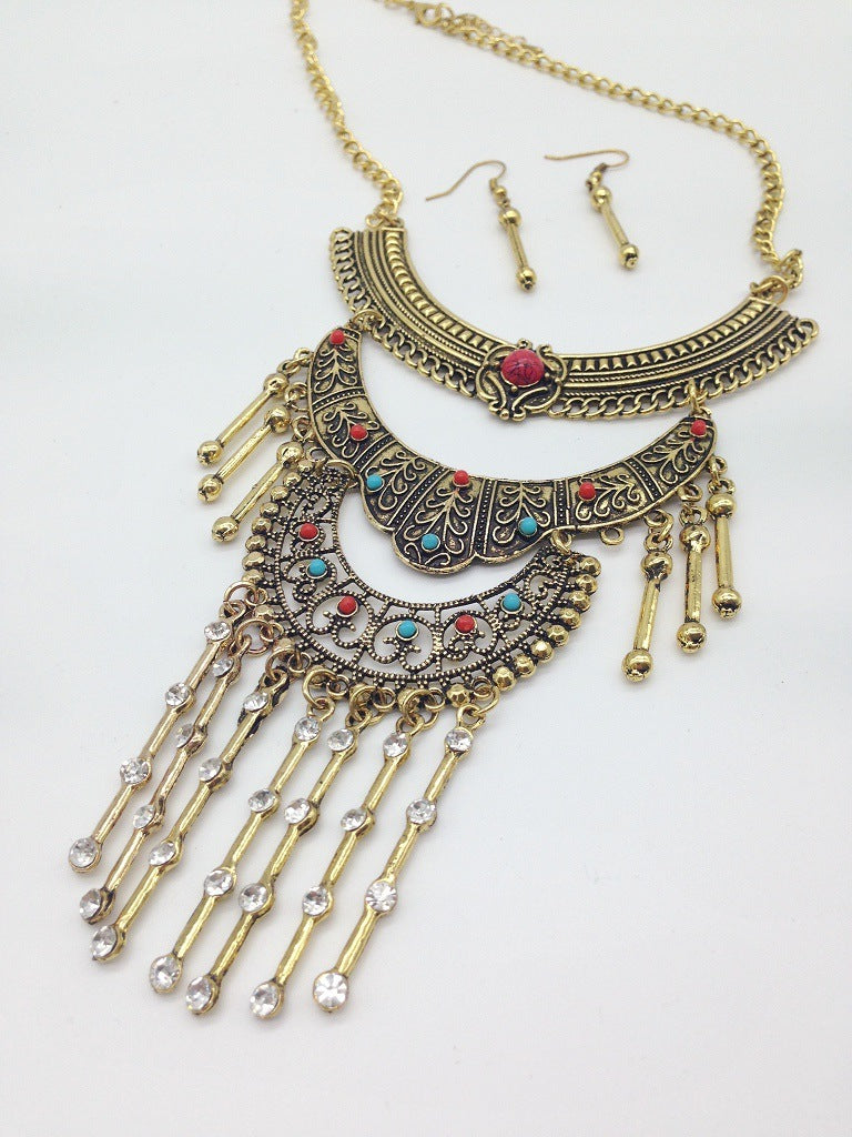 Ornate necklace with fringe and matching earrings on a white background