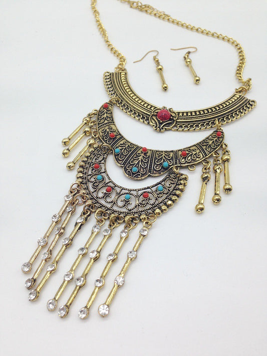 Ornate necklace with fringe and matching earrings on a white background