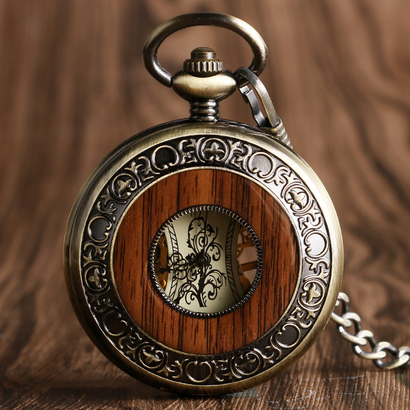 Vintage pocket watch with wooden face and intricate metalwork on a wooden background