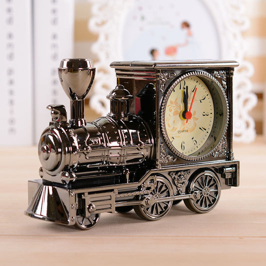 Vintage train-shaped clock on a wooden surface with a blurred background