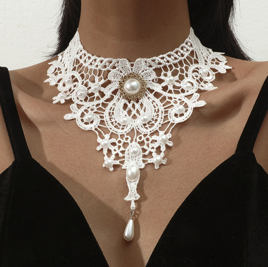White lace necklace with pearls on a model wearing a black top.