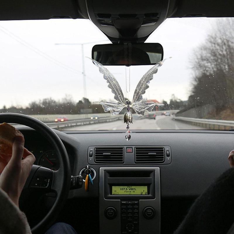 Car interior with a butterfly-shaped car hanging ornament on the rearview mirror.