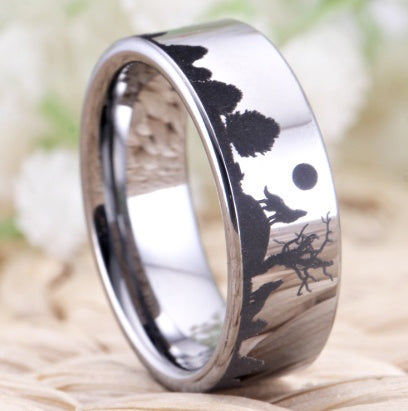 Silver ring with engraved design of a wolf and moon on a natural background