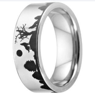 Silver ring with black engraved design on a white background