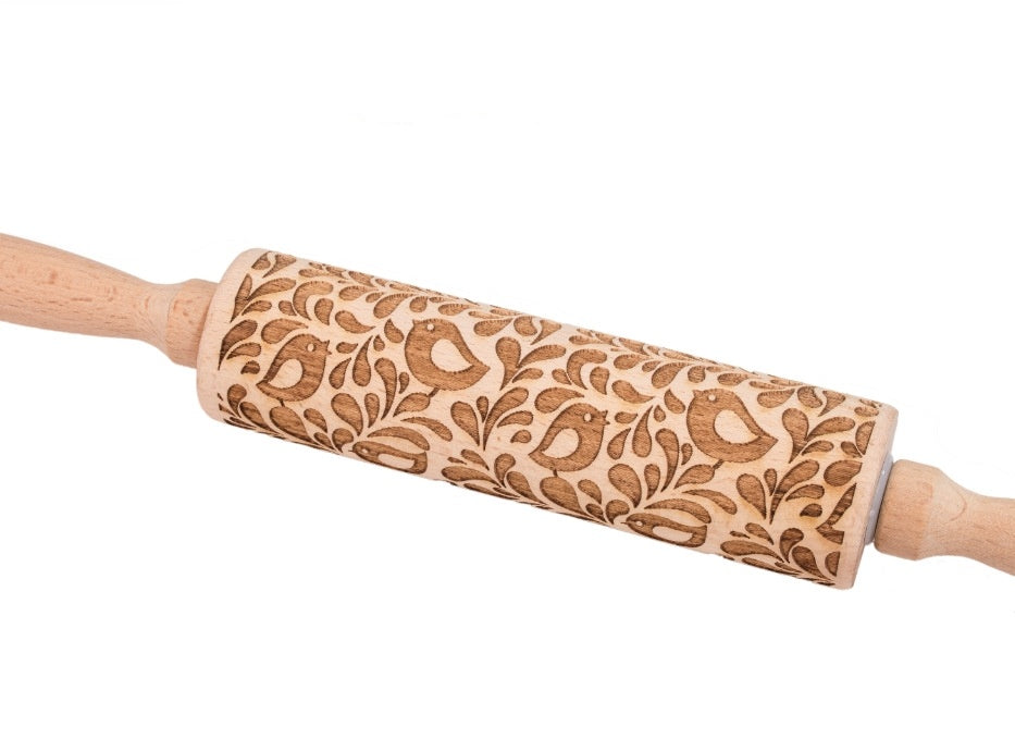 Wooden rolling pin with floral pattern on a white background