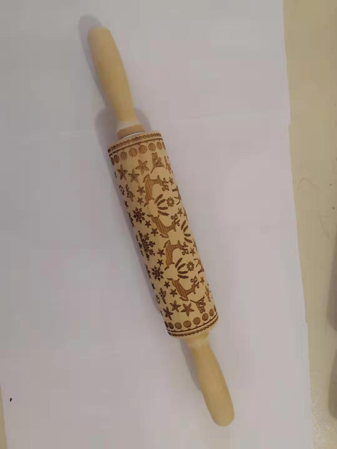 Decorative rolling pin with embossed designs on a white background
