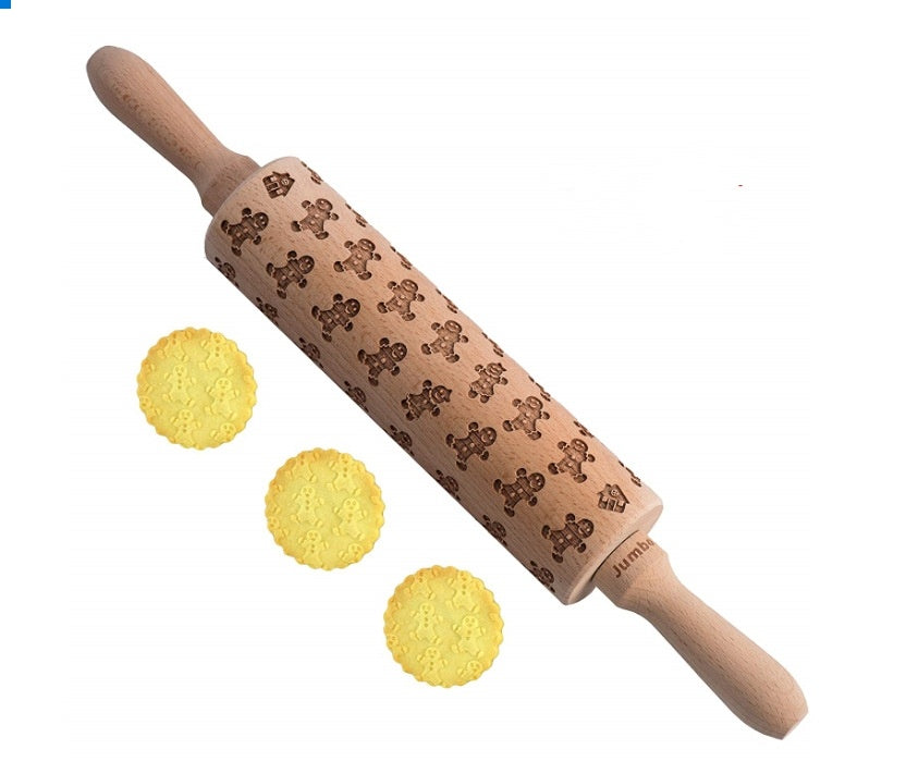 Wooden rolling pin with cookie cutter designs next to cookies on a white background