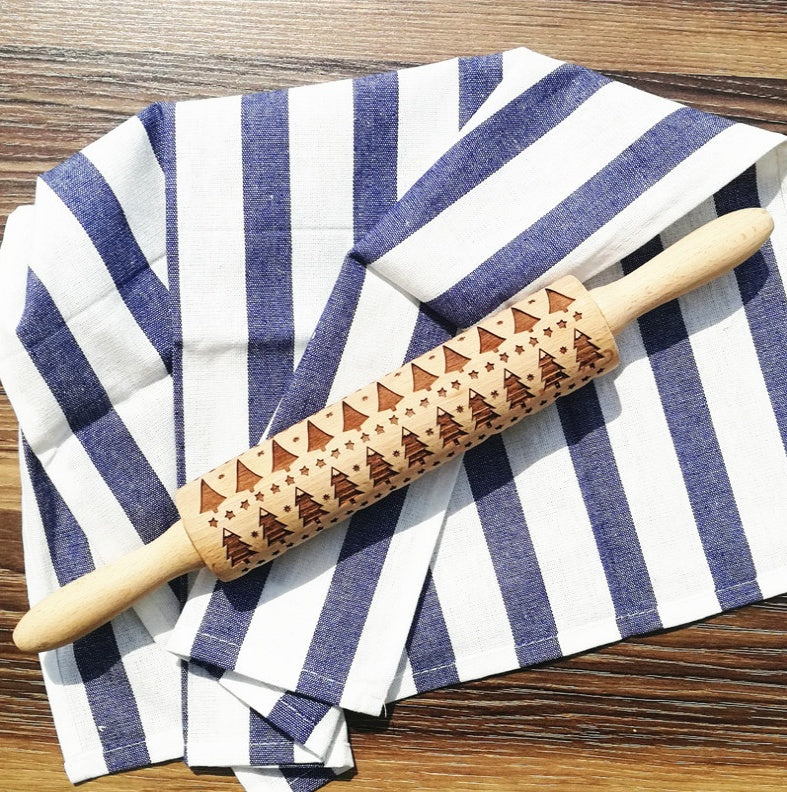 Wooden rolling pin with geometric patterns on a blue and white striped towel