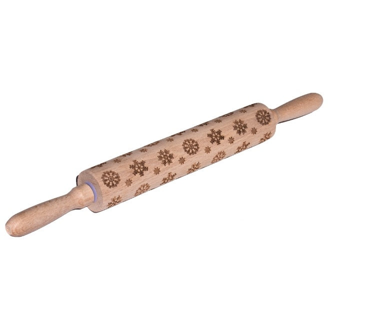 Wooden rolling pin with snowflake patterns on a white background