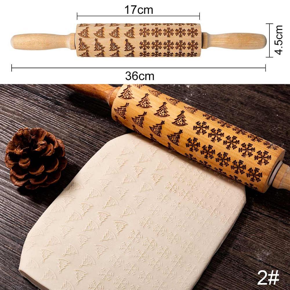 Wooden rolling pin with embossed patterns on a wooden surface with measurements shown.