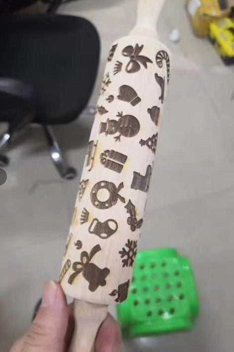 Rolling pin with decorative patterns held by a hand on a blurred background