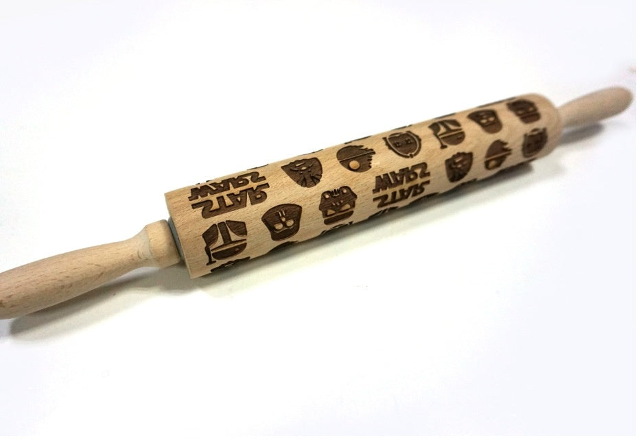 Wooden rolling pin with embossed designs on a white background