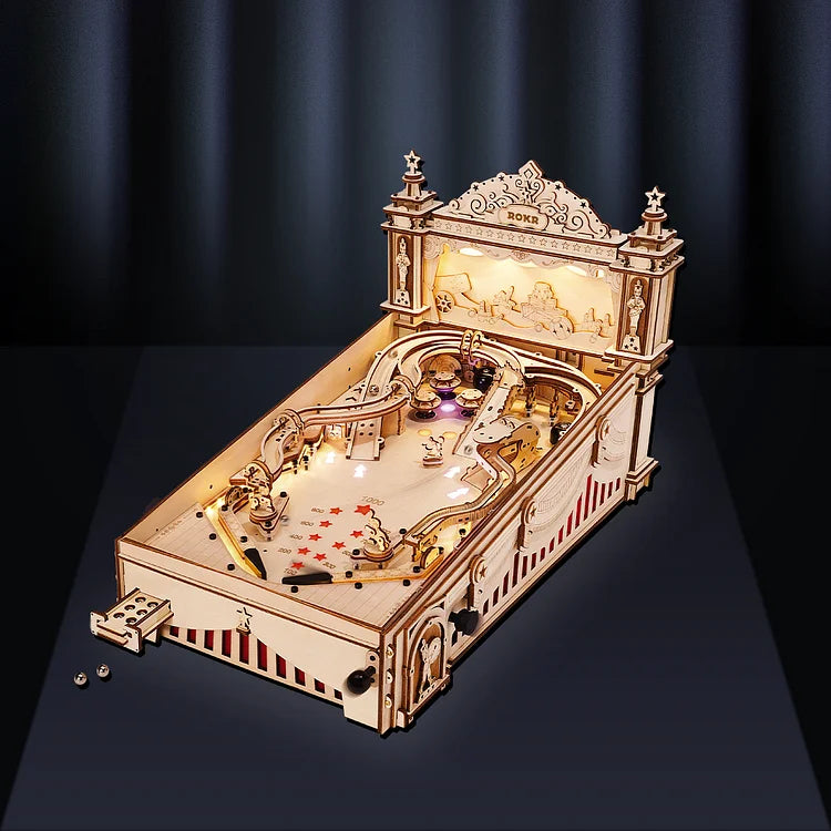 Wooden mechanical model of a pinball machine on a dark background