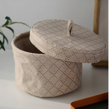 Woven storage basket with a lid on a light surface