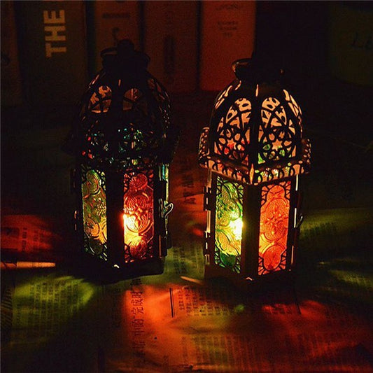 Two illuminated decorative lanterns on a dark surface with a blurred background.