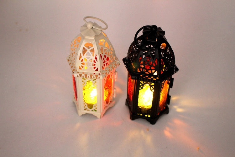 Two lit lanterns, one white and one black, on a light gray background.