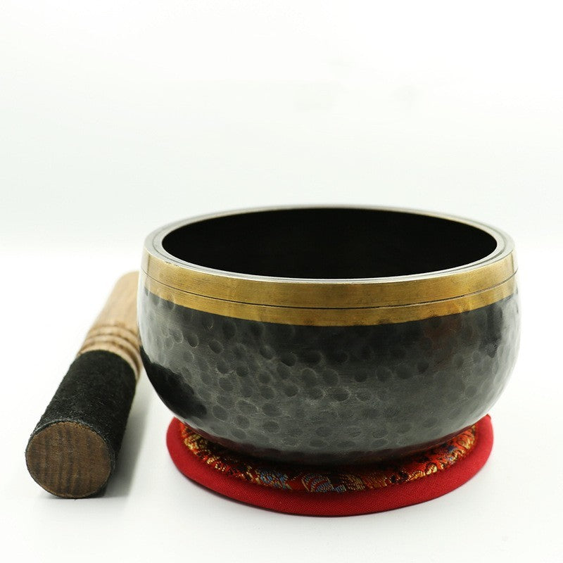 Tibetan singing bowl with a mallet on a white background