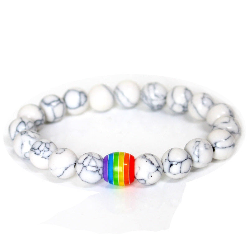 Bracelet with white marbled beads and a rainbow charm on a white background