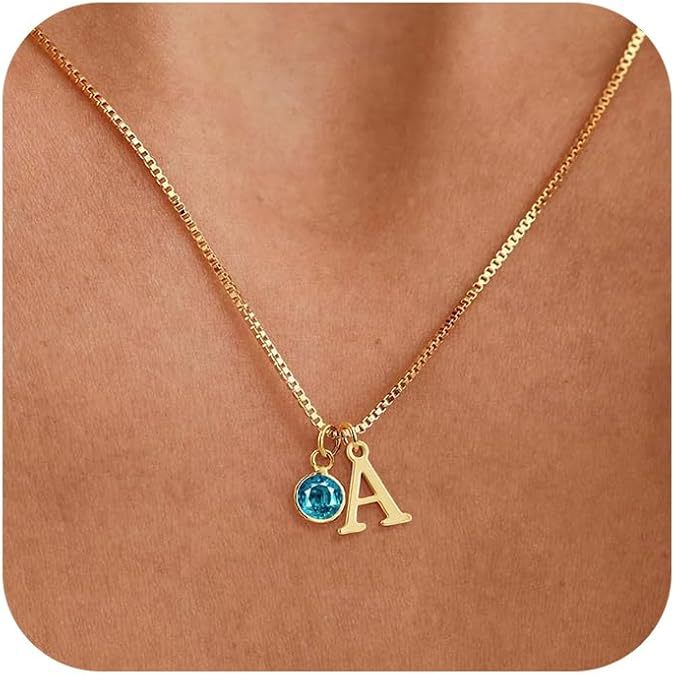 Gold necklace with a blue gemstone and letter 'A' pendant on a brown background