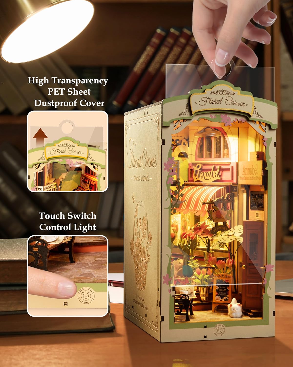 Light-up model of a floral cafe with a hand turning on the light, set against a blurred indoor background.