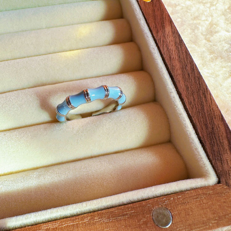 Blue ring with silver accents in a wooden jewelry box