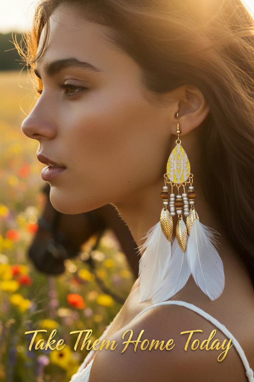 Pair of earrings with white feathers, gold leaves, and beads on a white background