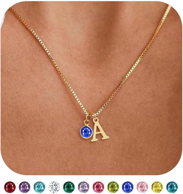 Gold necklace with a blue gemstone and gold letter 'A' pendant on a brown background.