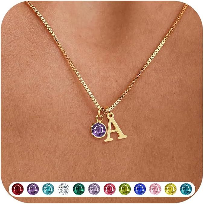 Gold necklace with letter 'A' pendant and purple gemstone on a brown background