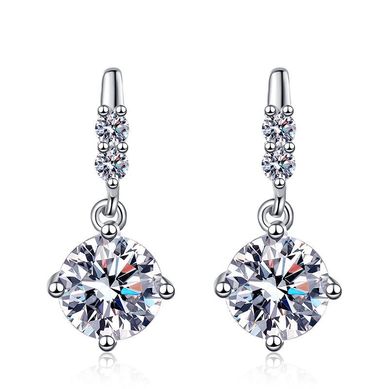 Pair of silver earrings with large clear gemstones on a white background