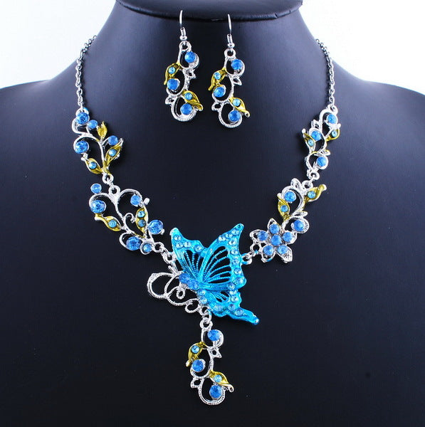 Jewelry set with blue butterfly pendant necklace and matching earrings on a black mannequin.